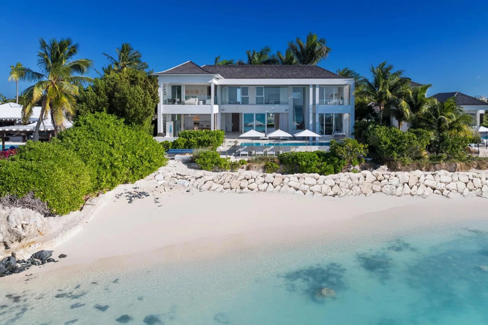 Oceanfront villa above a white sand beach and turquoise water at Beach Enclave Grace Bay